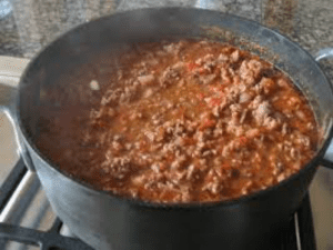 The Best Dutch Oven Chili Recipe Comes With BEANS 8 a pot of food on a stove